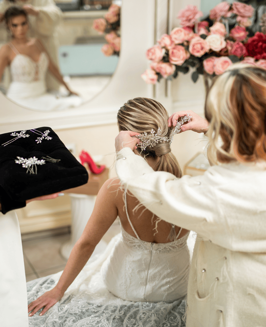 Bride getting hair styled with floral decorations.