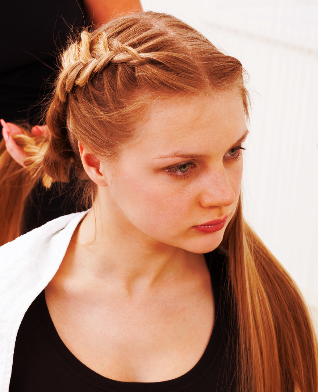 women getting her hair done in braids by a stylist